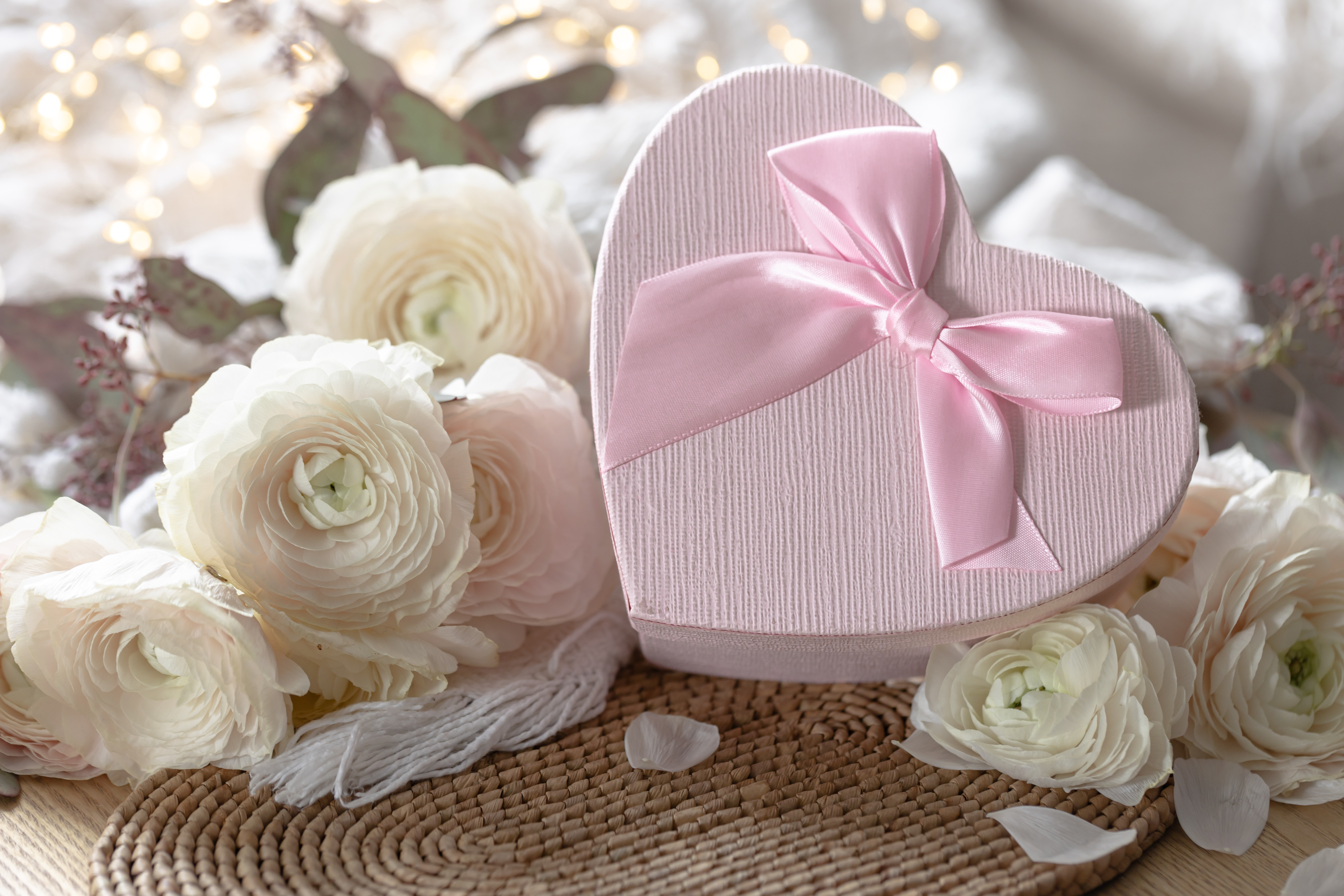 Herzförmige Geschenkbox zur Hochzeit mit rosa Schleife und weißen Ranunkeln